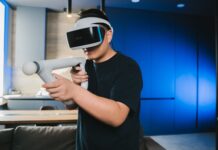 Mężczyzna w goglach VR grający w domu w sieciową grę 5G