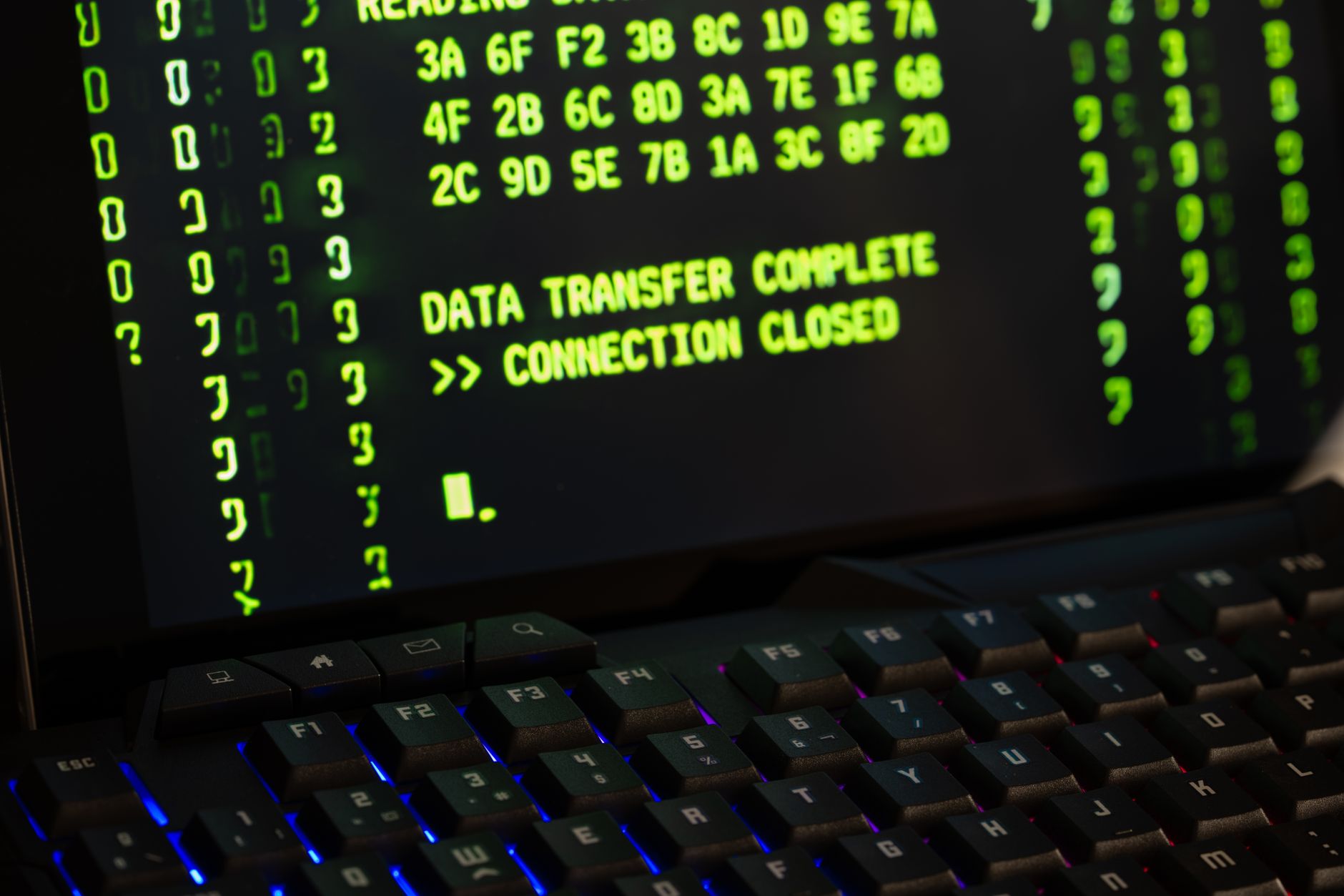 Monitor z komunikatem o zakończonym transferze danych i klawiaturą