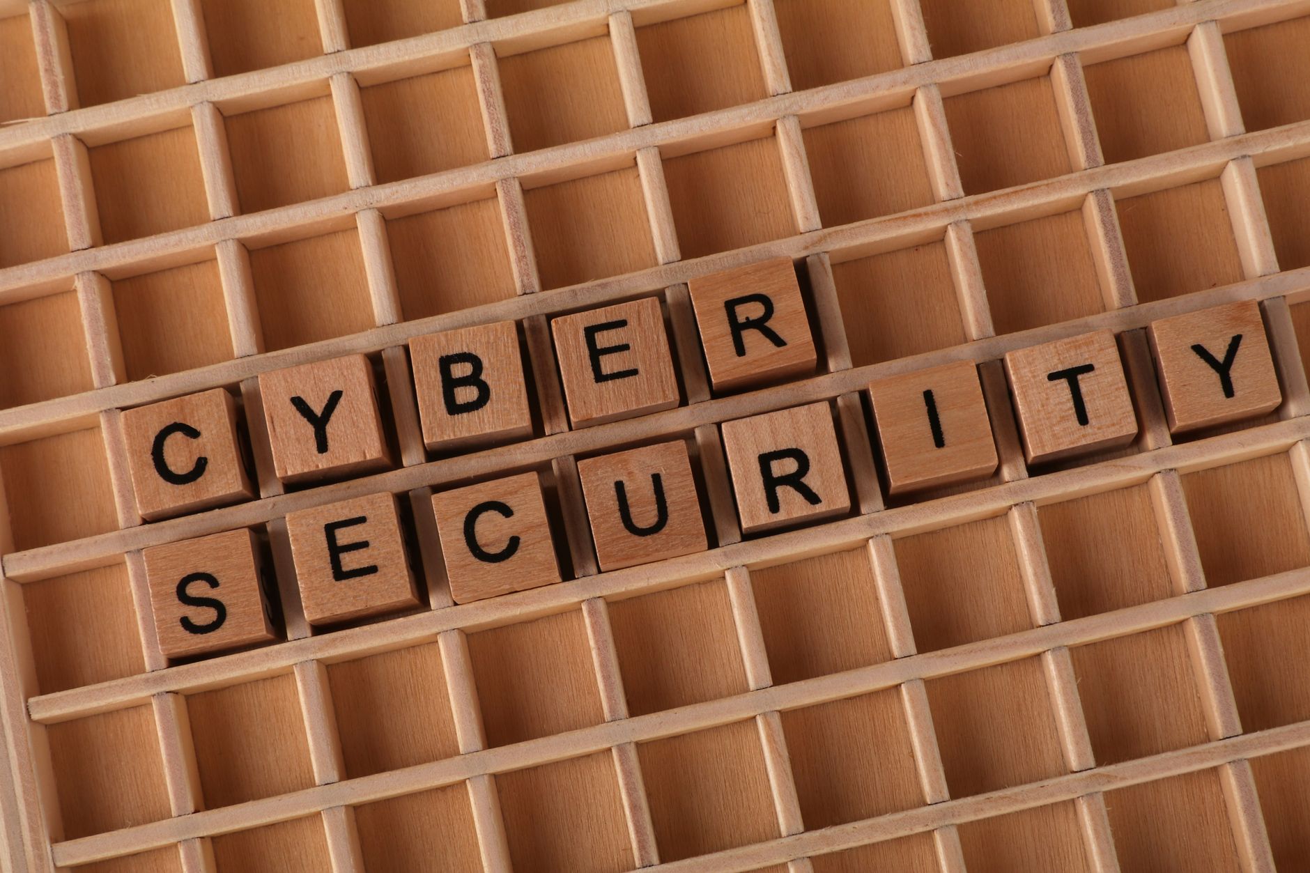 Drewniane klocki układające napis Cyber Security na drewnianym tle