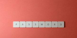 Kostki na klawiaturze układające słowo PASSWORD na koralowym tle