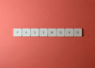 Kostki na klawiaturze układające słowo PASSWORD na koralowym tle