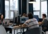 Zespół programistów pracuje przy komputerach w nowoczesnym biurze tech