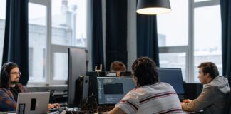 Zespół programistów pracuje przy komputerach w nowoczesnym biurze tech